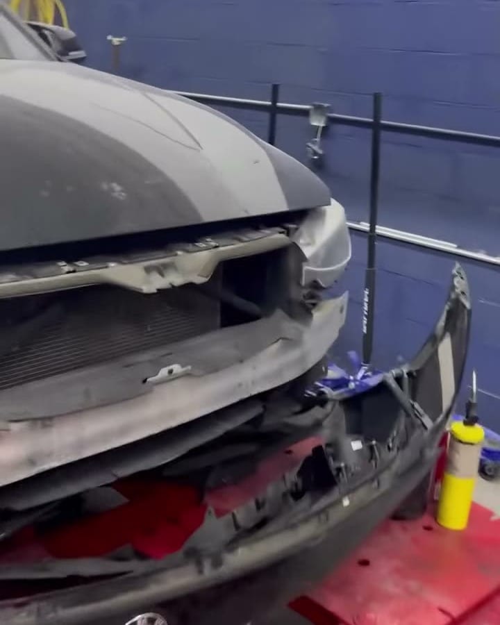 Black BMW clamped on the red frame rack with the front end apart